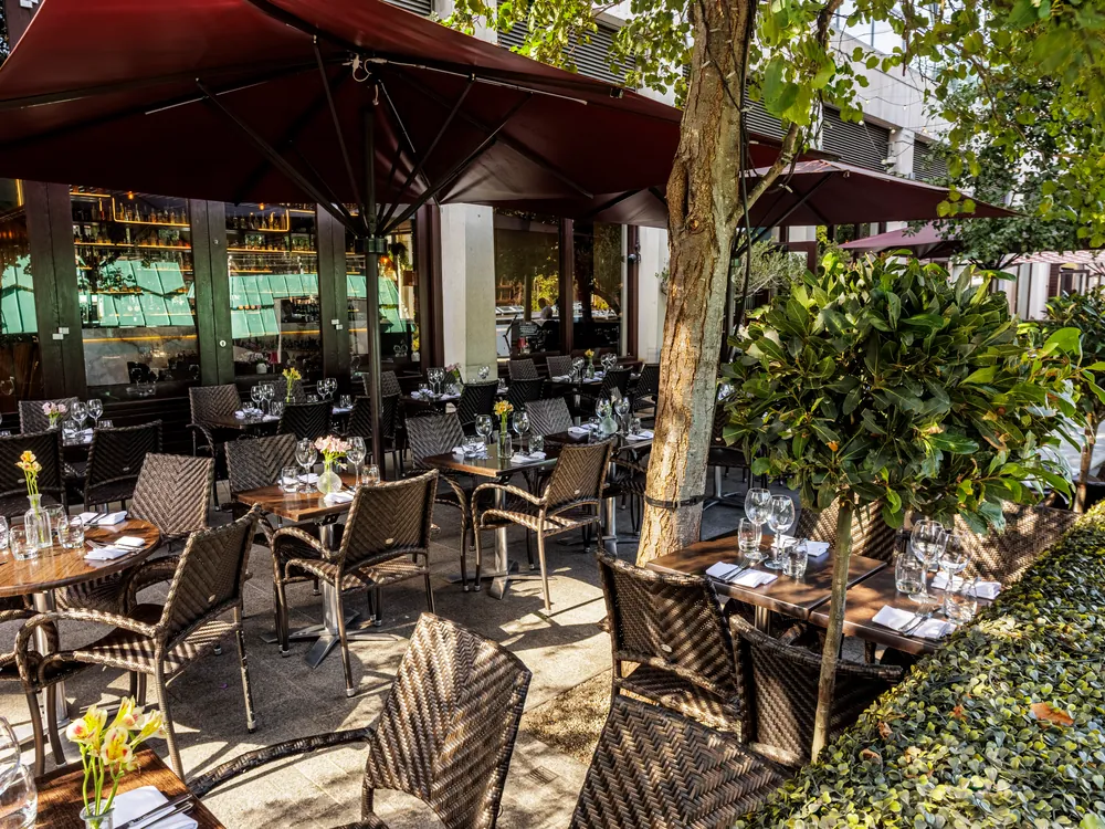 Terrace tables set by the trees at Smith's Bar & Grill